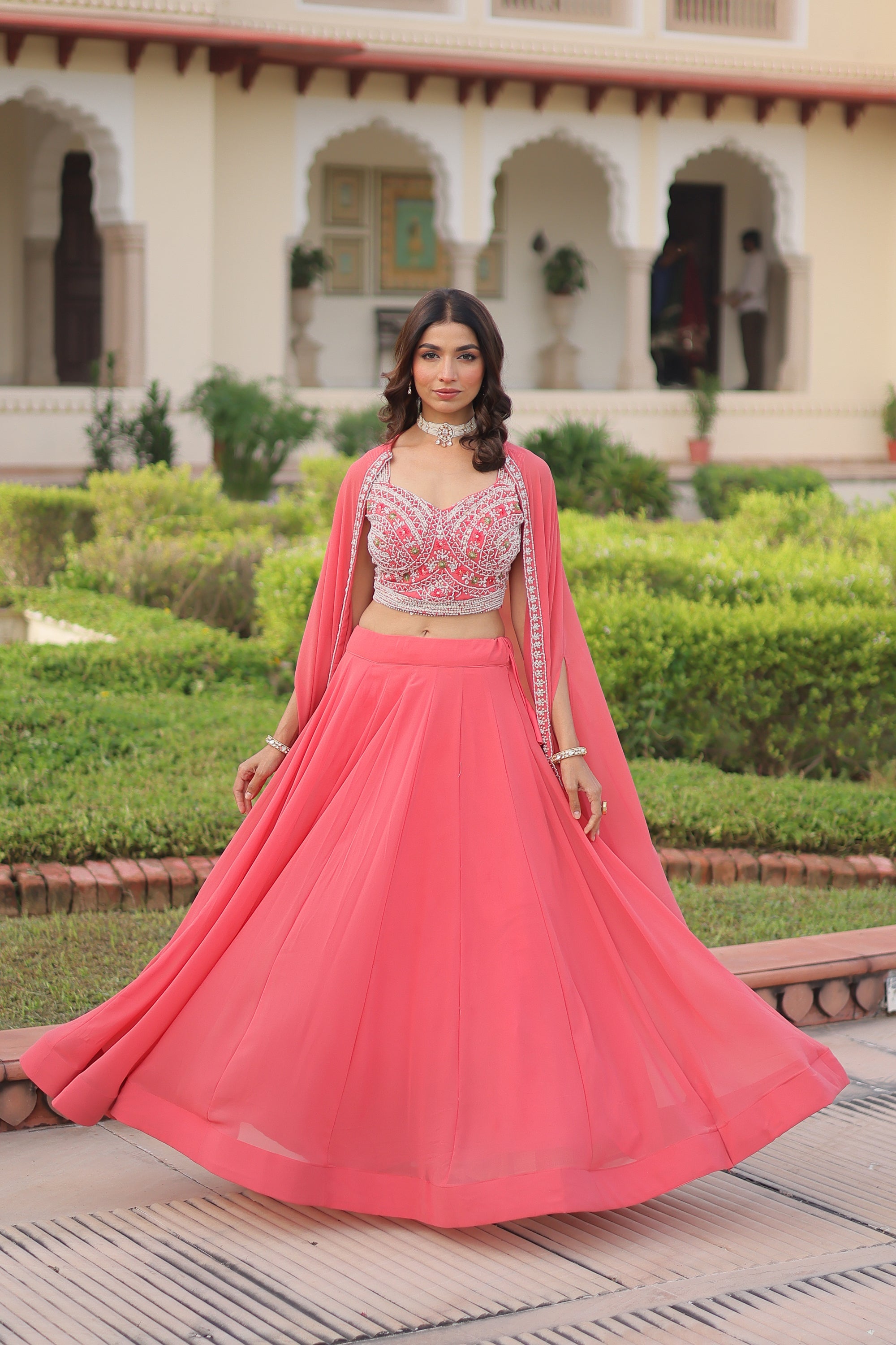 Peach faux georgette lehenga choli with a matching shrug