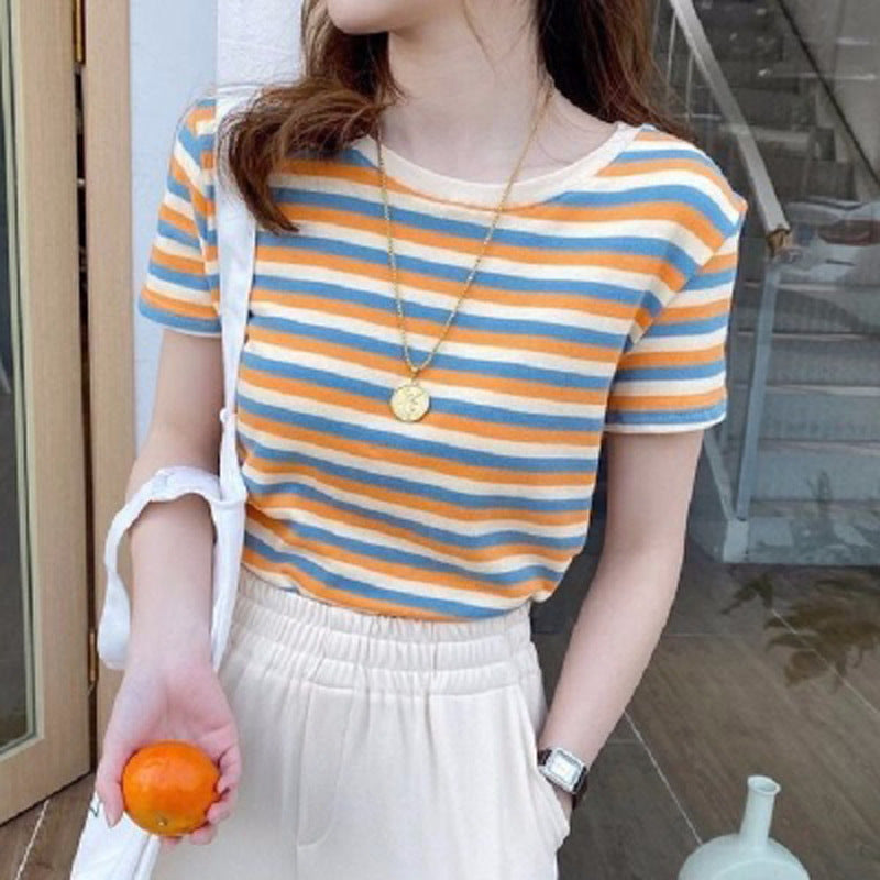 Woman wearing a slim-fit short sleeve striped t-shirt styled with a necklace and casual trousers