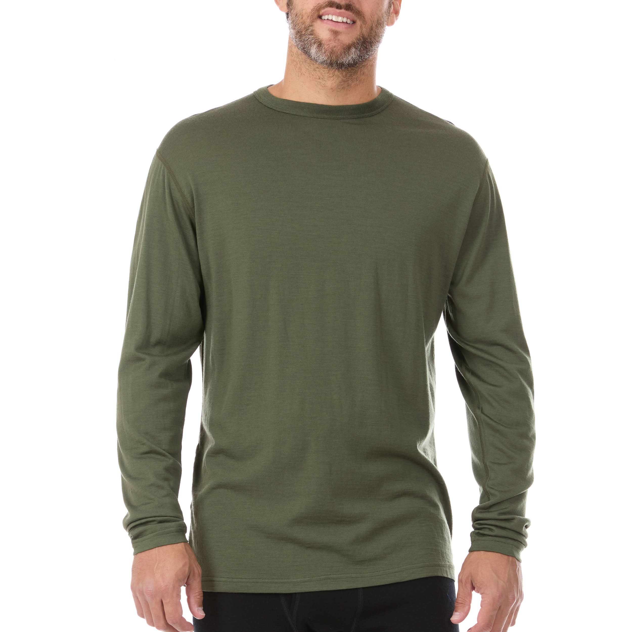 A man wearing a lightweight olive green 100% Merino wool crew neck long-sleeve shirt in an outdoor setting.