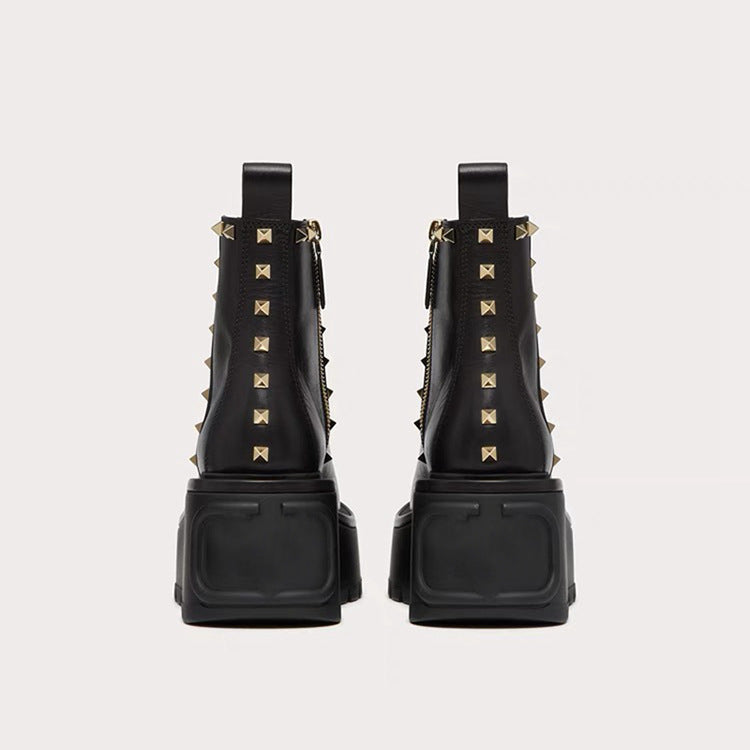 Pair of black chunky platform Chelsea ankle boots with gold rivets and side zippers