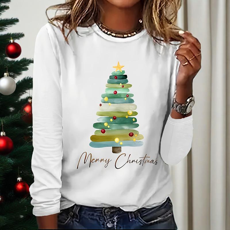 A woman wearing a white long sleeve t-shirt with a festive watercolor Christmas tree graphic and Merry Christmas text