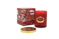 A luxurious Portus Cale glass candle in deep ruby red with gold accents and a botanical floral print.