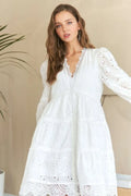 White babydoll dress with lace detail and tiered eyelet hem