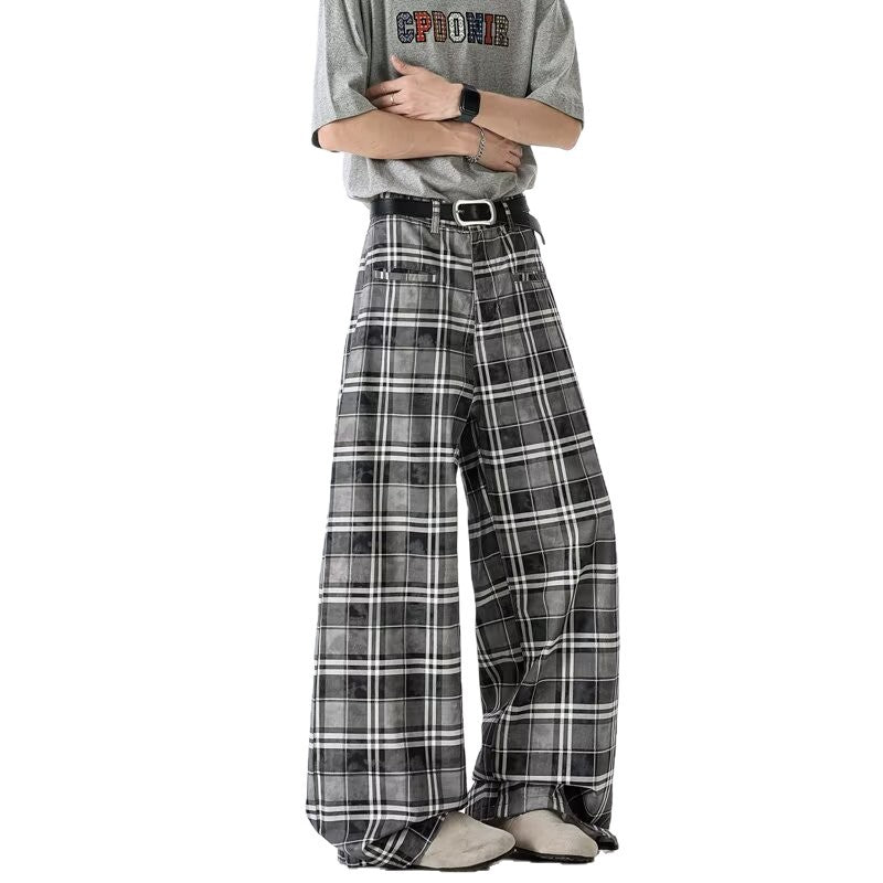 A person wearing wide leg plaid pants in gray with a belt and gray t-shirt, showcasing a casual streetwear style.