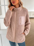 A woman wearing a cozy plush fuzzy zip-up long sleeve jacket for cold weather.
