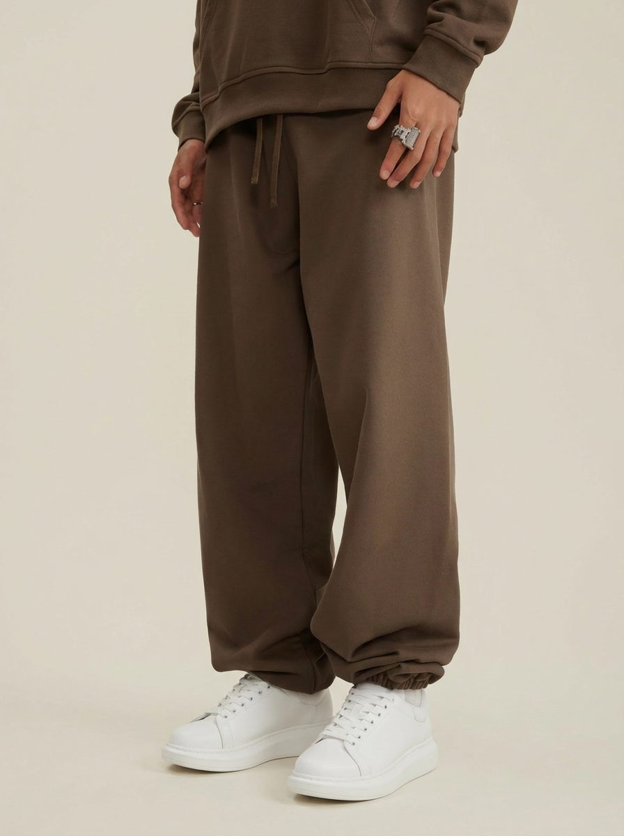 A pair of brown heavyweight 440 GSM cotton joggers with a loose, relaxed fit.