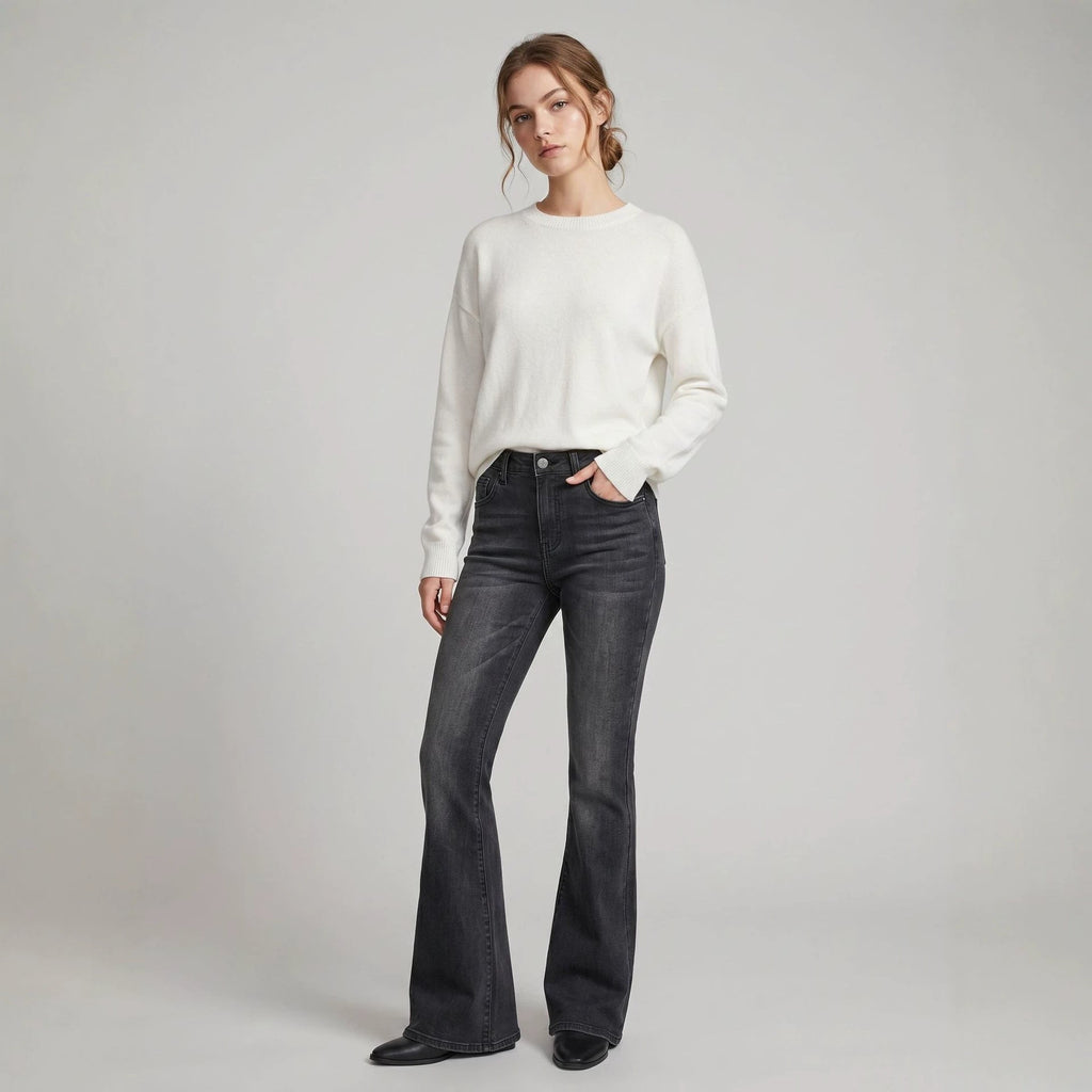 A pair of high-waist slim-fit flared jeans in blue denim, styled with a minimalist contemporary look.