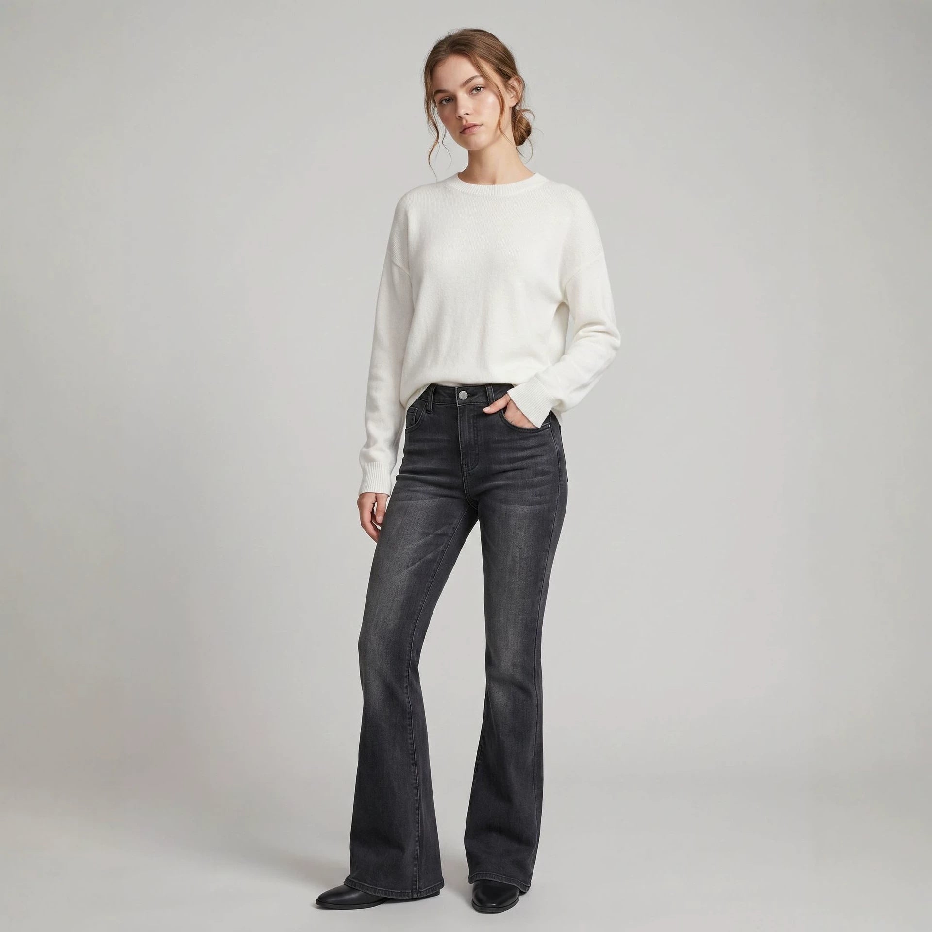 A pair of high-waist slim-fit flared jeans in blue denim, styled with a minimalist contemporary look.