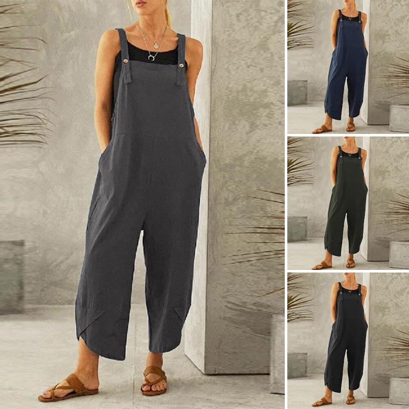Woman wearing a dark grey solid color casual wide-leg overall jumpsuit with a black tank top and sandals.