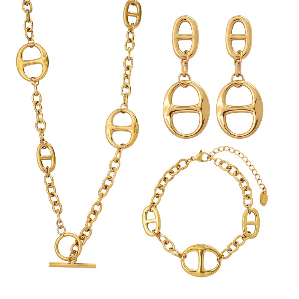 A complete jewelry set featuring an 18K gold geometric sun necklace, bracelet, and stud earrings.