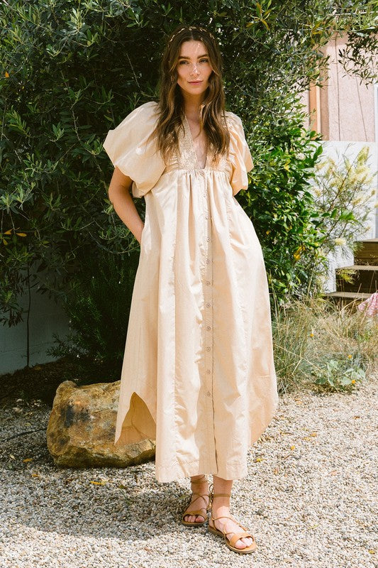 A woman wearing a feminine smocked puff sleeve midi dress with a flattering silhouette.