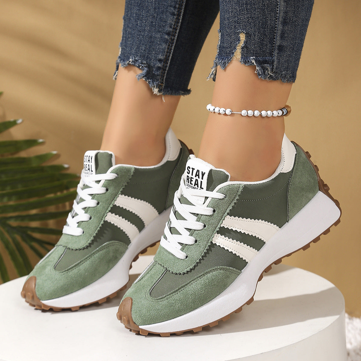 Close up of a pair of chunky platform sneakers featuring green and yellow colorways with white laces and white thick soles.