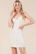 Close up of lace detailing on an elegant mini cami dress with adjustable straps.