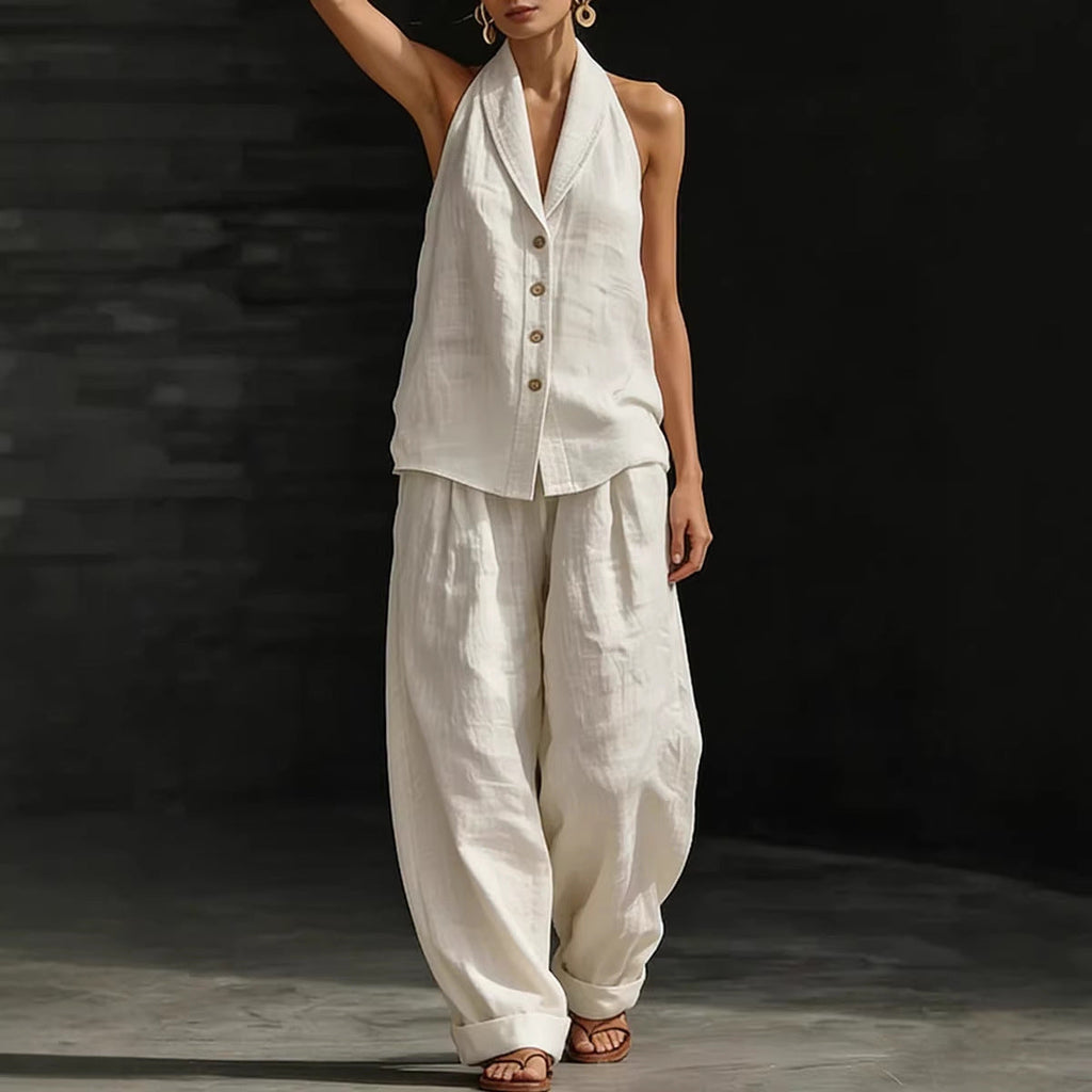 A woman wearing a white sleeveless collared button-front vest and matching wide-leg cotton-linen pants.