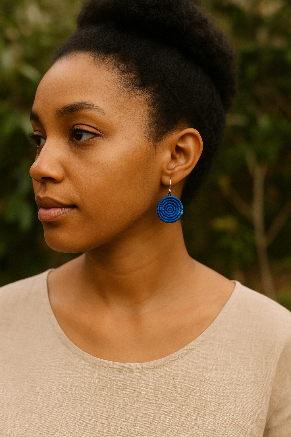 Colorful geometric spiral earrings made from natural fibers and thread, handcrafted in Uganda.