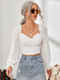 Model wearing a semi-sheer mesh sweetheart neck top with flounce sleeves and ruffle detailing