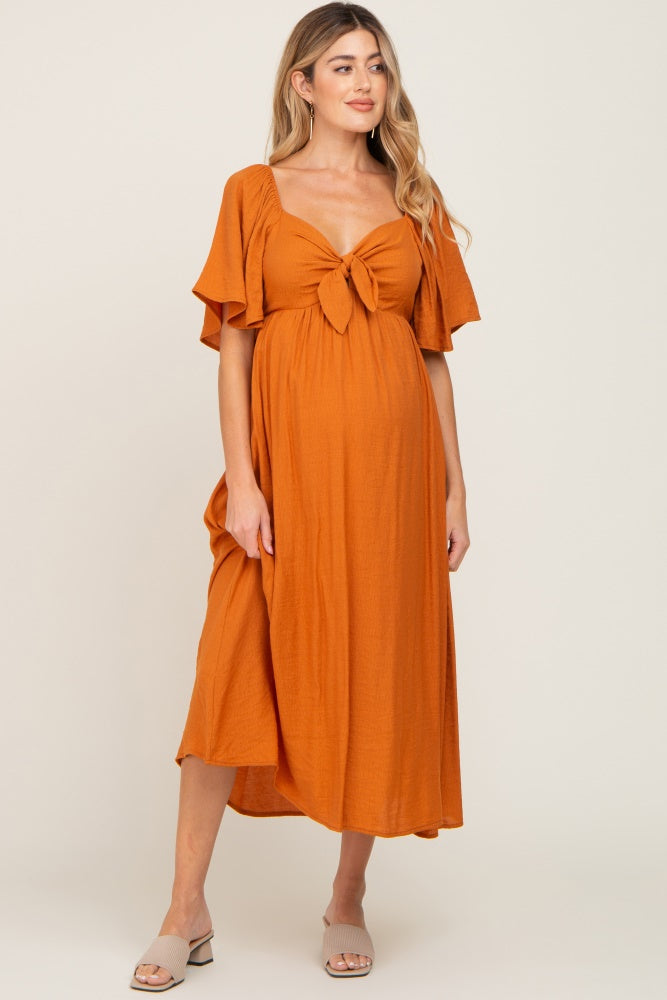 Rust colored maternity midi dress with front tie and ruffle sleeves