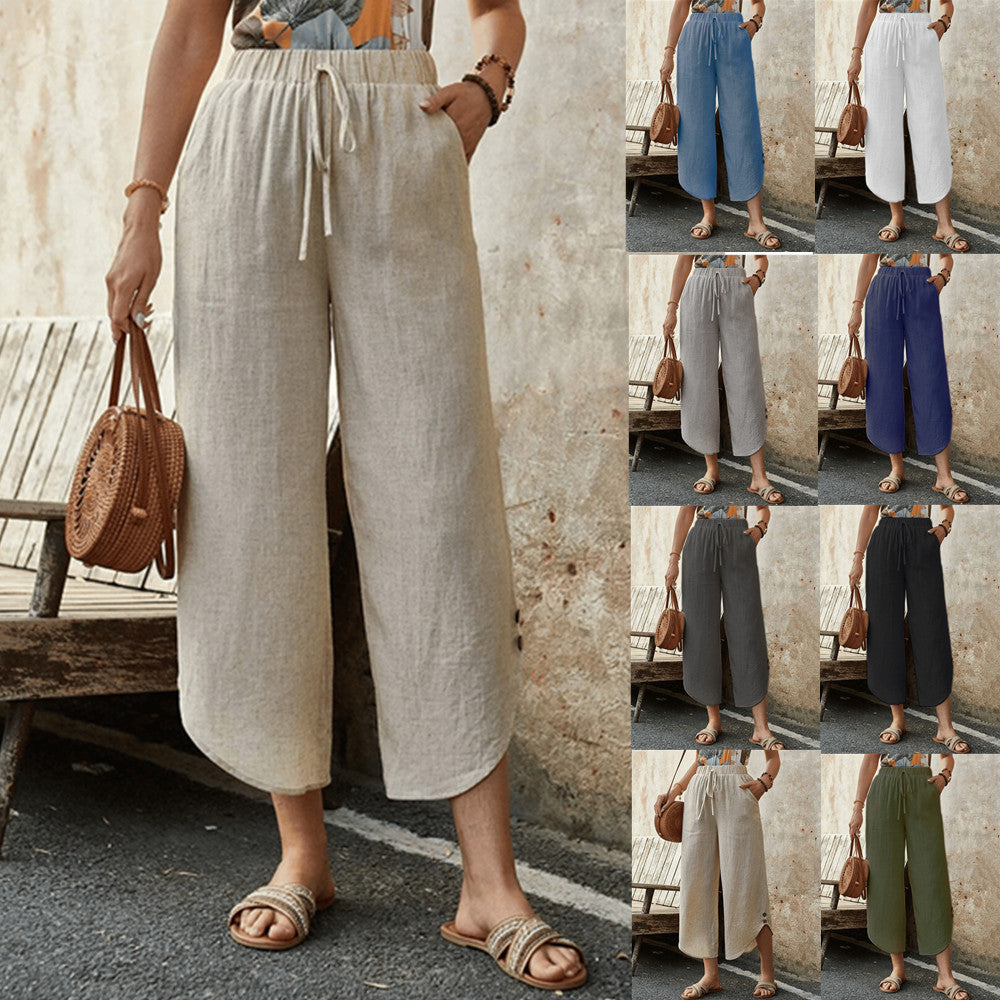 A woman wearing beige cotton-linen cropped drawstring pants with a relaxed fit, featuring side pockets and a curved hemline.