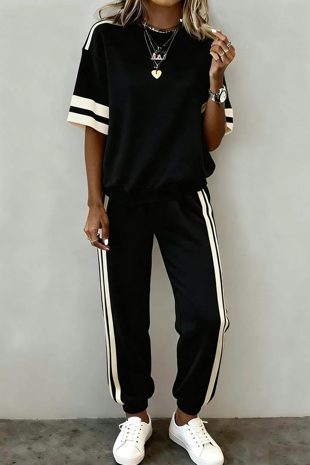 Woman wearing a Leona Striped Detail Loose Tee with black and white colorblock pattern and insert pockets