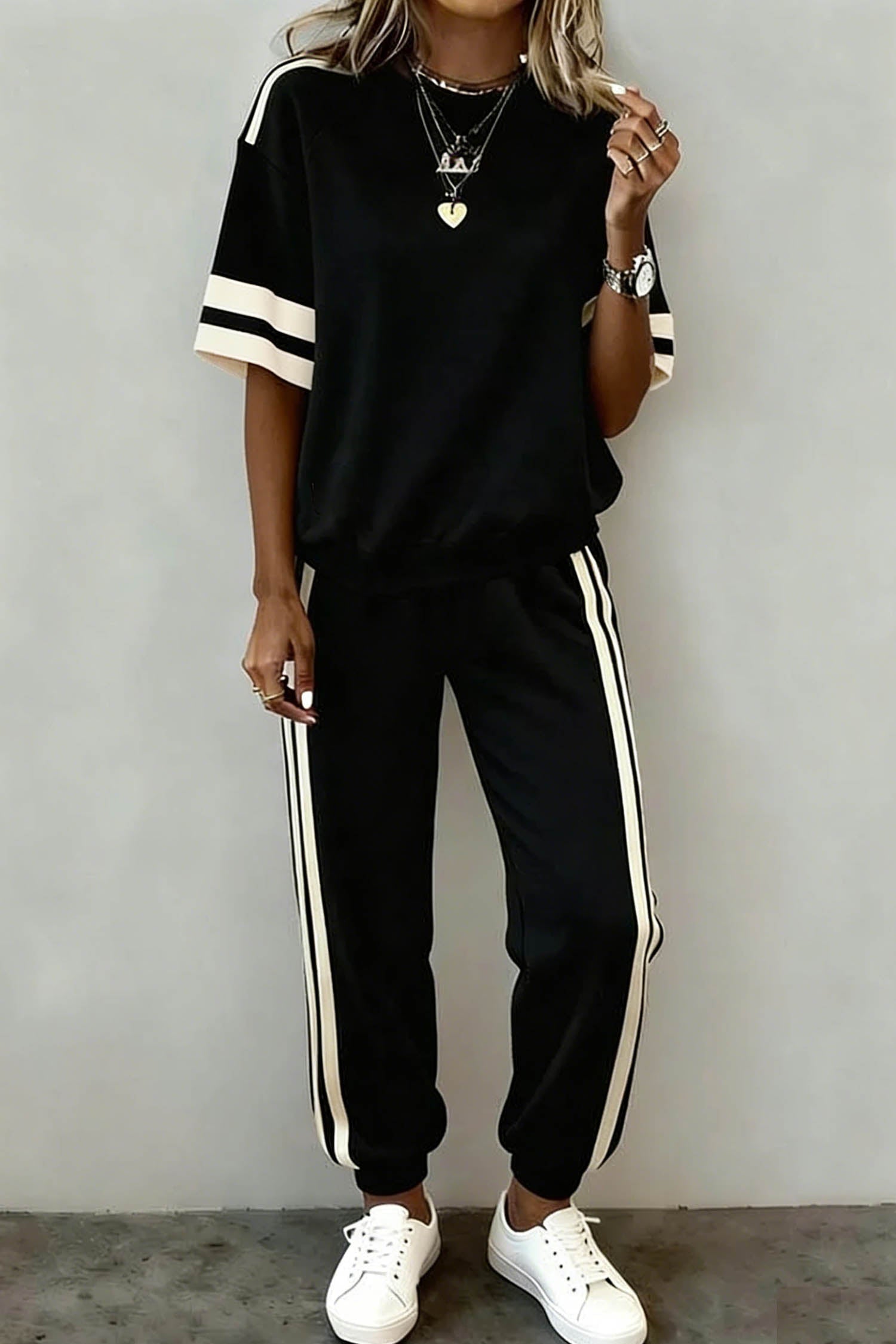 Woman wearing a Leona Striped Detail Loose Tee with black and white colorblock pattern and insert pockets