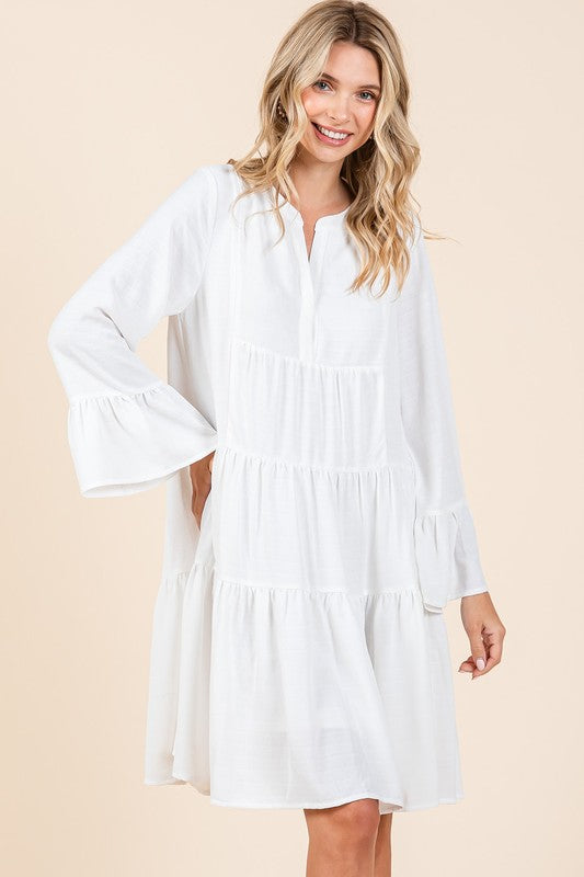 A stylish white tiered dress with flare sleeves and a notched neckline