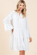 A stylish white tiered dress with flare sleeves and a notched neckline