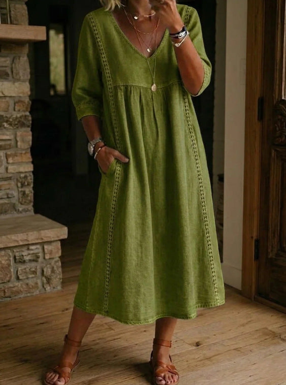A woman wearing a relaxed fit linen cotton midi dress with lace trim detailing, V-neckline, and side pockets.