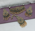 Close up of a vibrant teal blue alloy choker necklace set on a neutral background