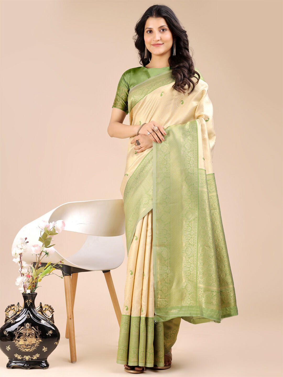 Woman wearing a Cream and Light Green Banarasi silk saree with intricate traditional patterns