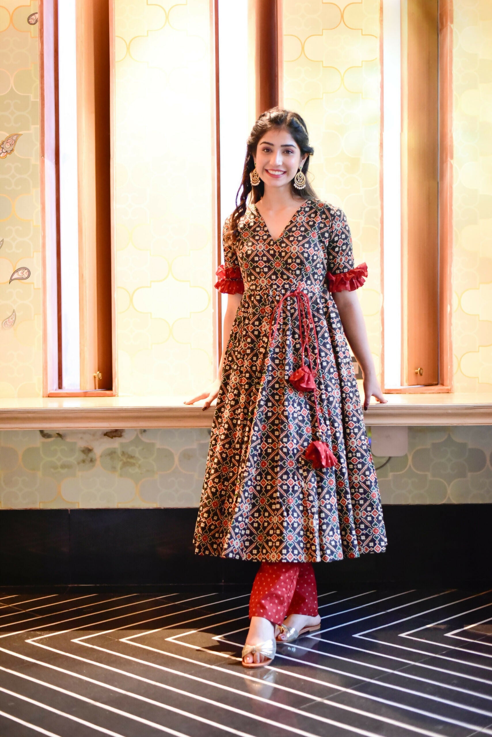 Women wearing a black cotton silk knee-length kurta with digital prints and matching pants