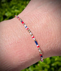 Close up of a patriotic red, white, and blue seed bead and gold-filled bead bracelet on a wrist.