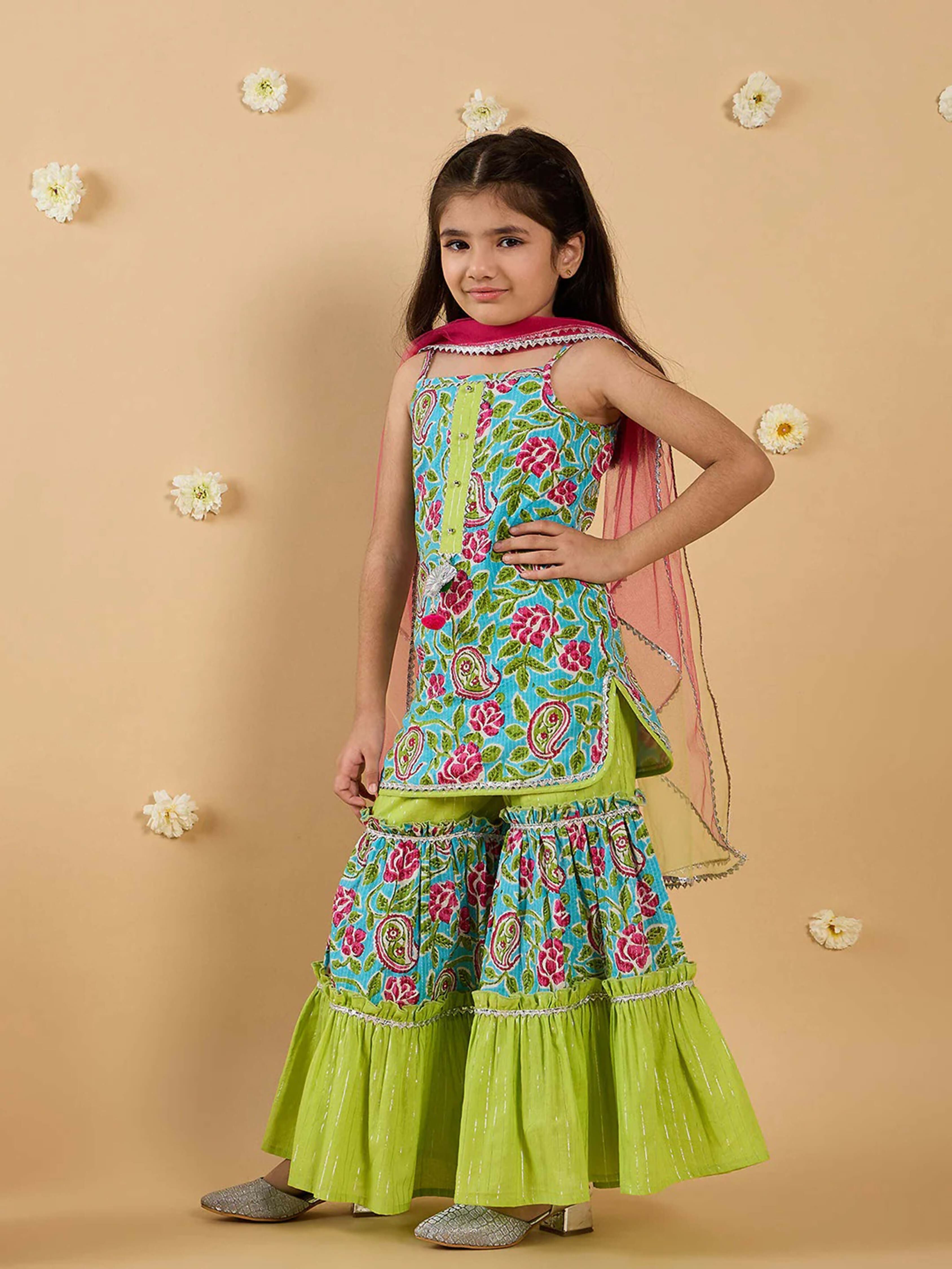 Girl wearing a multi-color floral print sharara set with lime-green accents and a pink dupatta