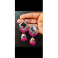 Close-up of pink handcrafted mirror work earrings for traditional Indian wear