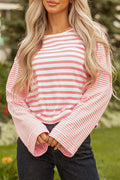 Woman wearing a pink and white colorblock striped textured knit long sleeve top with dropped shoulders