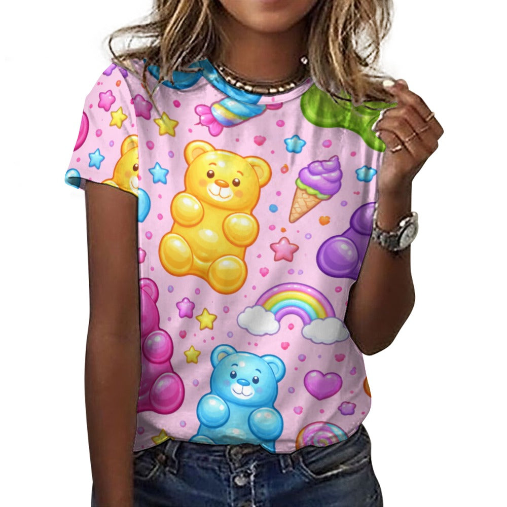 Woman wearing a pink short sleeve t-shirt with a vibrant, colorful gummy bear, stars, rainbow, and ice cream pattern, styled casually.