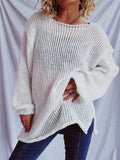 Woman wearing a white long sleeve boat neck dropped shoulder knit sweater with side slits