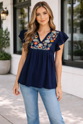 Close up of Erin Embroidered Babydoll Blouse featuring floral embroidery and double ruffle sleeves