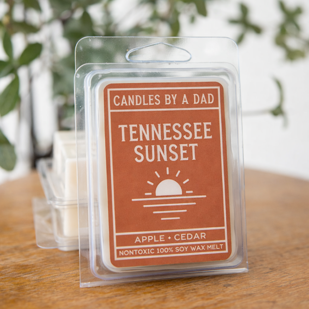 A pack of Tennessee Sunset wax melts in clear plastic packaging with a rustic orange label on a wooden table.