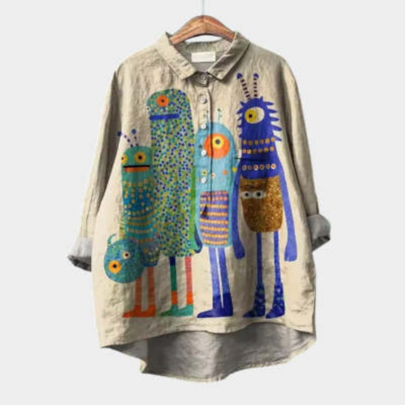 A beige button-down shirt with a collar featuring a colorful, whimsical monster graphic print.