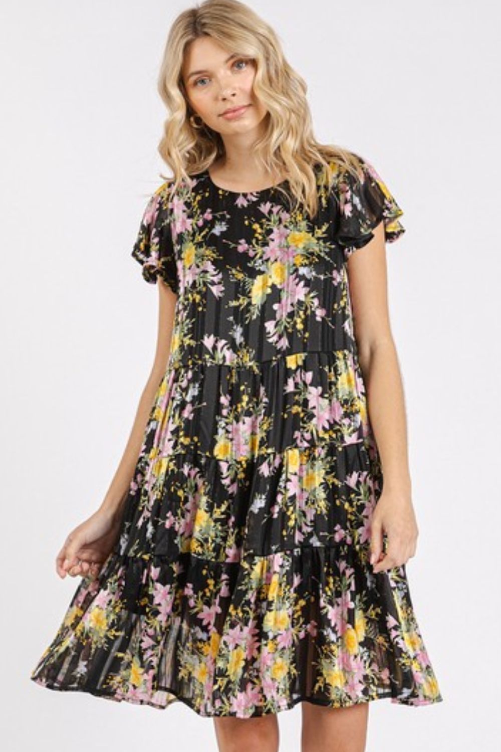 Model wearing a romantic floral print chiffon tiered dress with flutter sleeves.