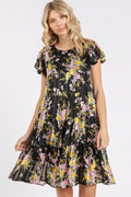 Model wearing a romantic floral print chiffon tiered dress with flutter sleeves.