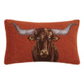 Rectangular 20x12 longhorn hooked wool lumbar pillow with rust background and velvet backing on a rustic living room sofa.