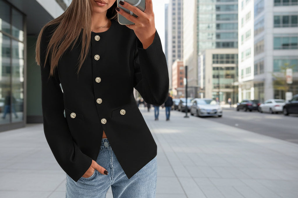 A woman wearing a black long-sleeve round neck button-down cardigan with gold buttons.