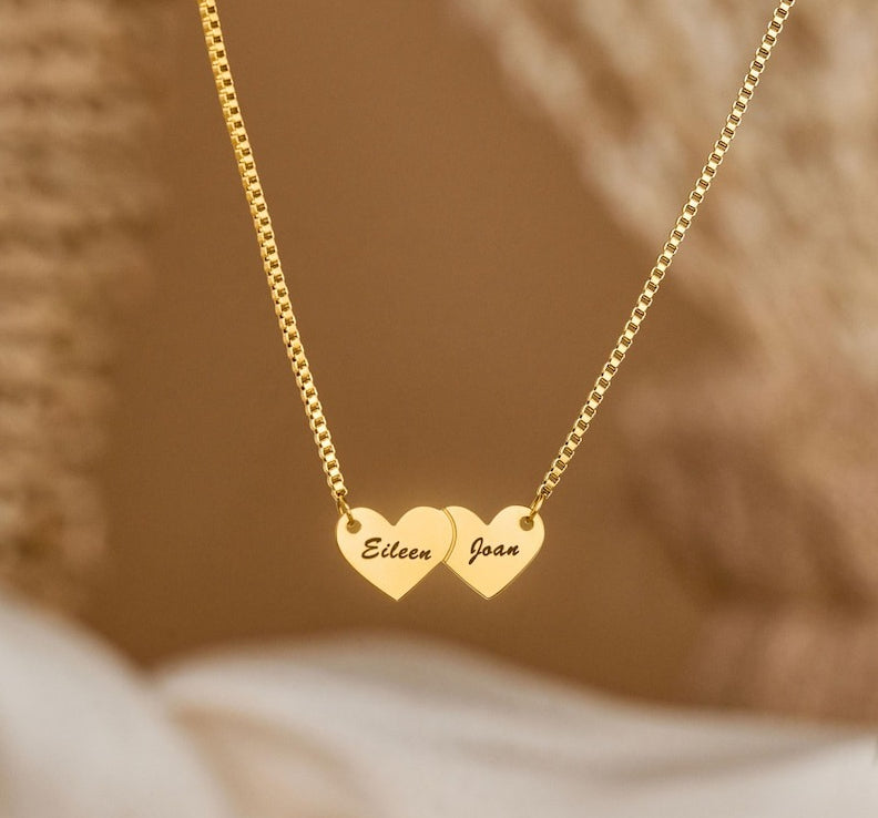 Gold interlocking heart pendant necklace featuring custom cursive name script.