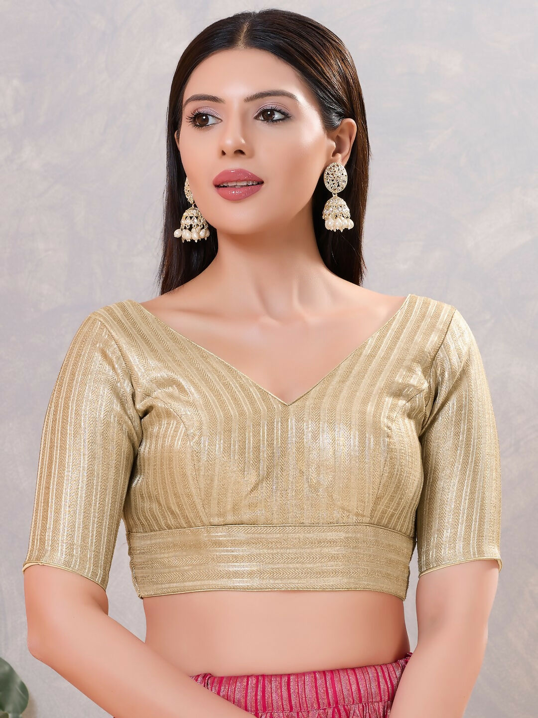Woman wearing a sophisticated light-gold jacquard stitched blouse for festive ethnic styling.