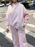 Relaxed fit light pink and white big striped sweatpants for men and women.