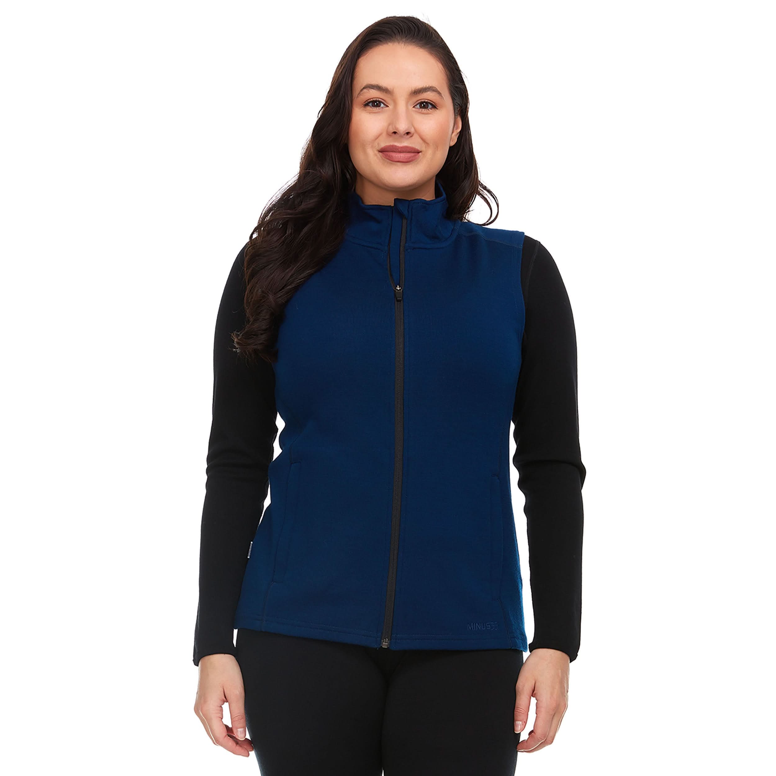 Woman wearing a minimalist 100% Merino wool navy vest with a zip-up front and collared neckline.