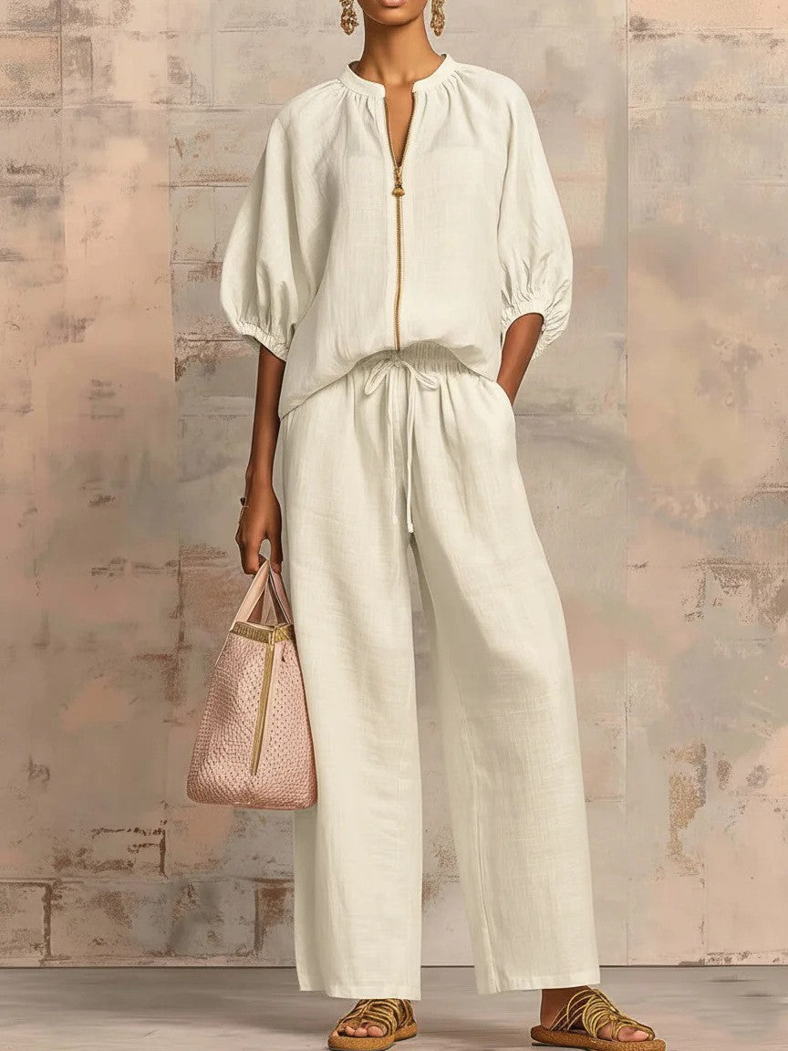 A woman wearing a casual loose-fit two-piece set with a zipper round neck top, bubble sleeves, and matching wide-leg pants.
