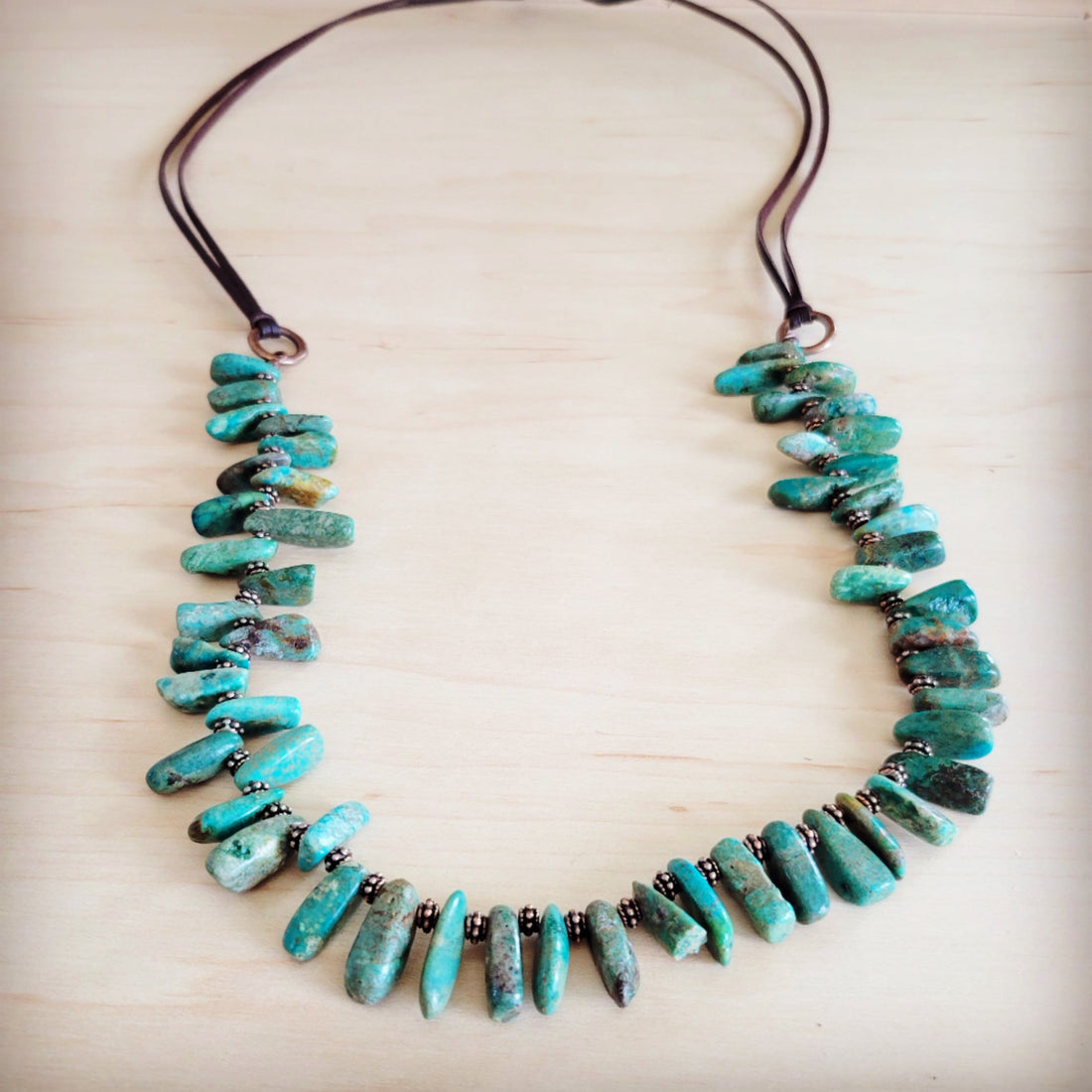 A handmade stacked turquoise stone necklace featuring genuine brown leather ties and natural Oregon turquoise beads.