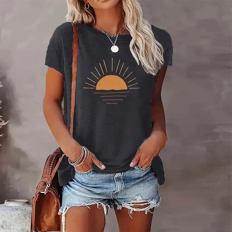 Model wearing a dark gray round neck t-shirt with a stylized orange sunrise graphic print, styled with denim shorts.